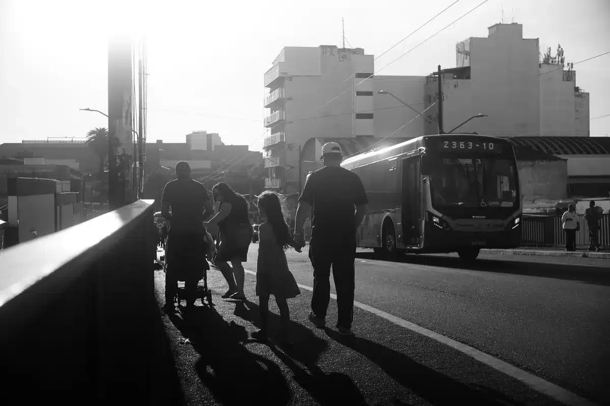 School bus stop in morning light with empty bench and backpacks
