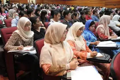 Students practicing a speech in a sunlit classroom, teacher listening nearby