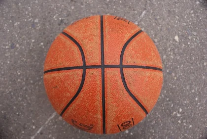 Female basketball player shooting a buzzer-beater with crowd in background during a close game