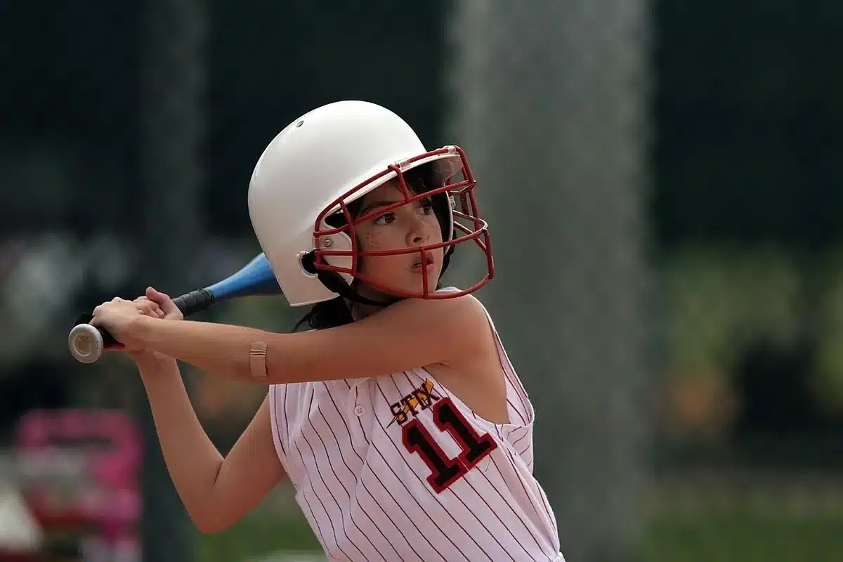 High school softball batter following through on a powerful swing