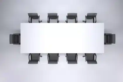 Delegates around a table with documents and daylight from large windows
