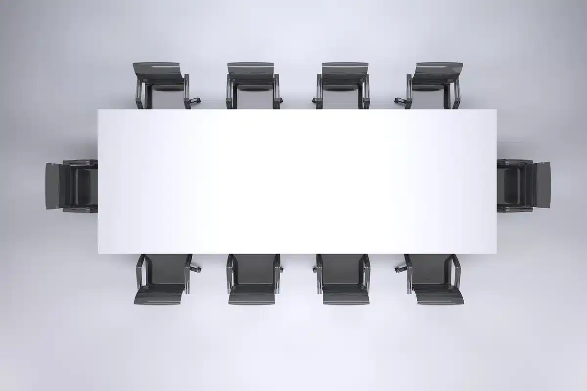 Delegates around a table with documents and daylight from large windows
