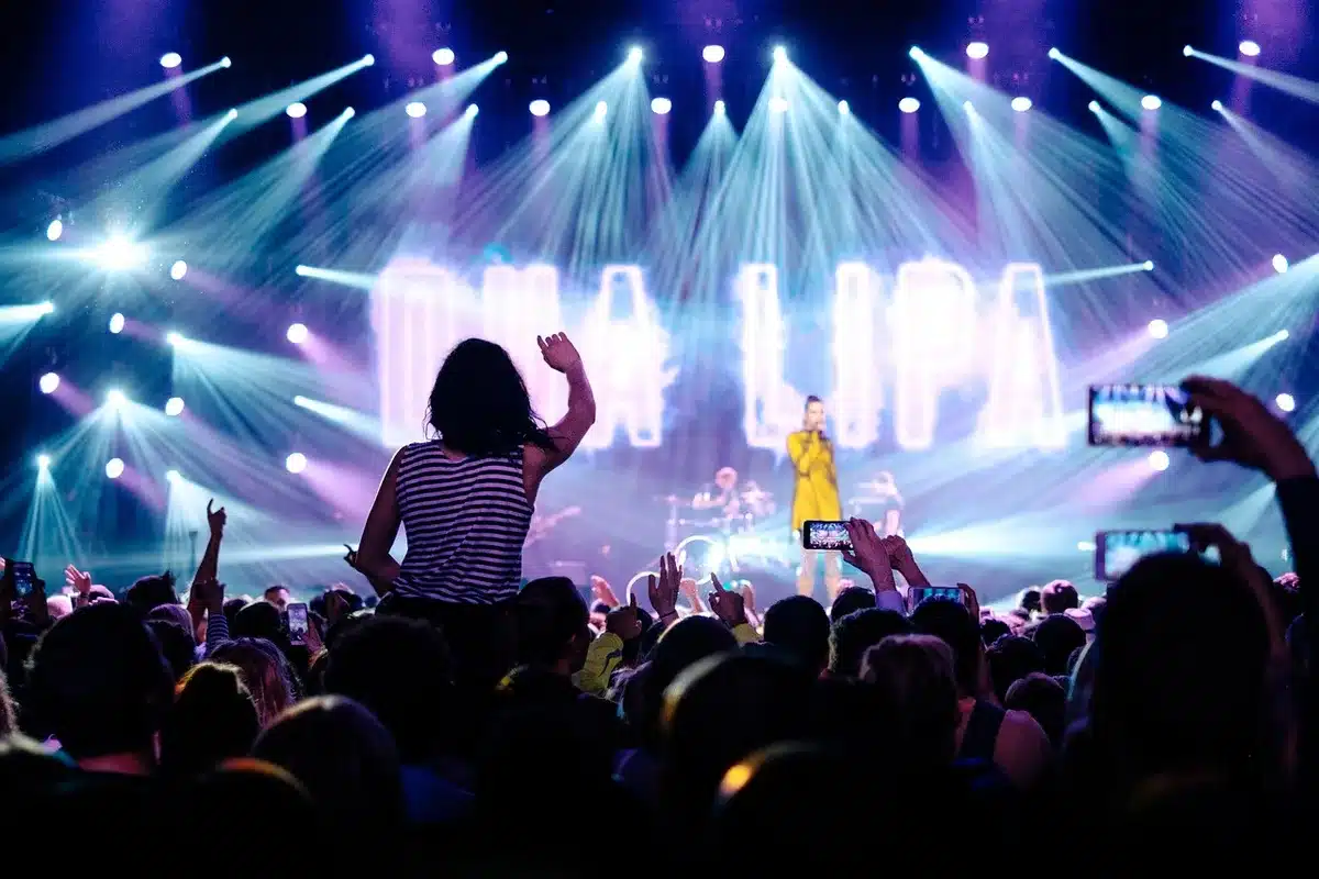 Band performing on an outdoor country stage with audience in daylight