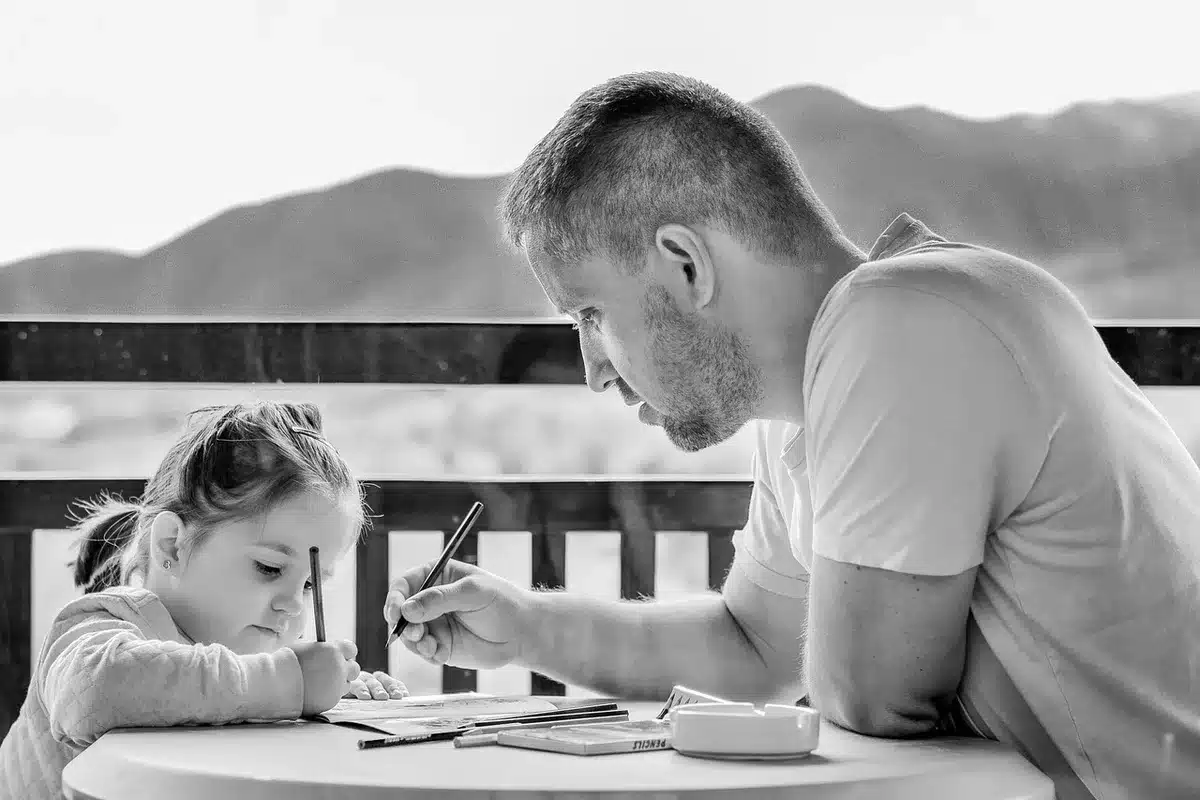 Parent reviewing a child’s account information on a laptop in daylight